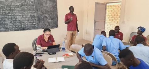 Pastor Mabior leading the training in the classroom in front of a chalkboard.