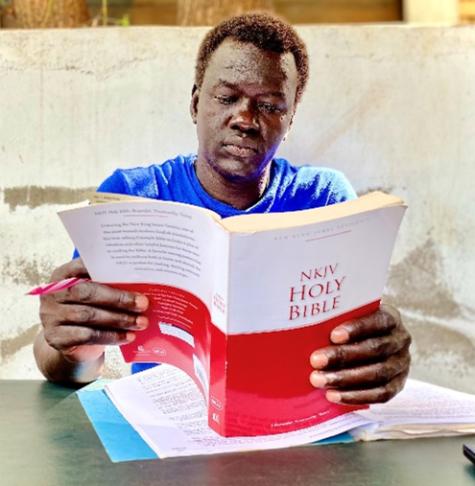 Pastor Mayom reading his bible