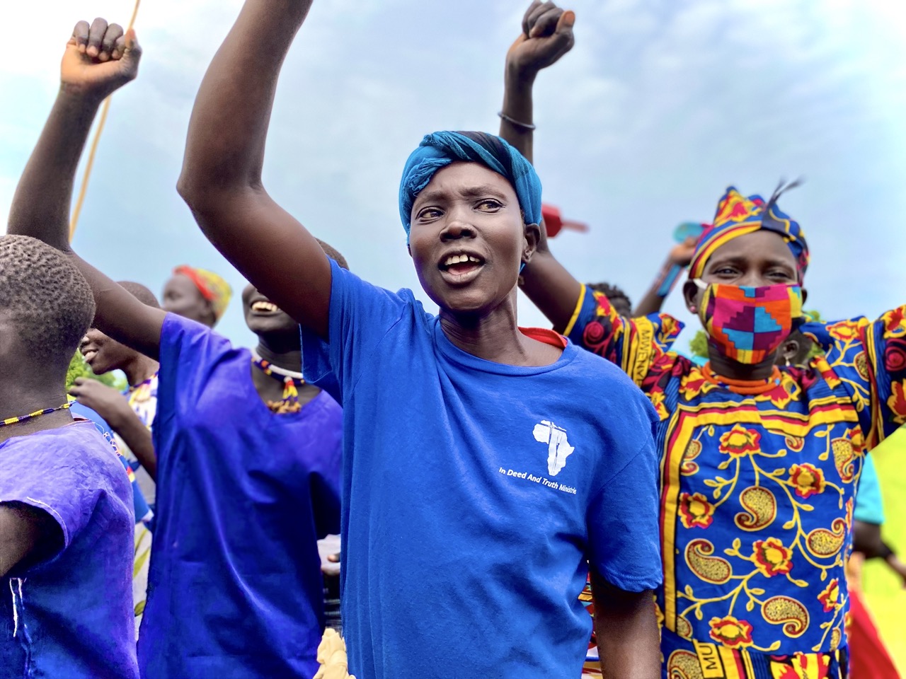 Group of people holding their hands up and praising.