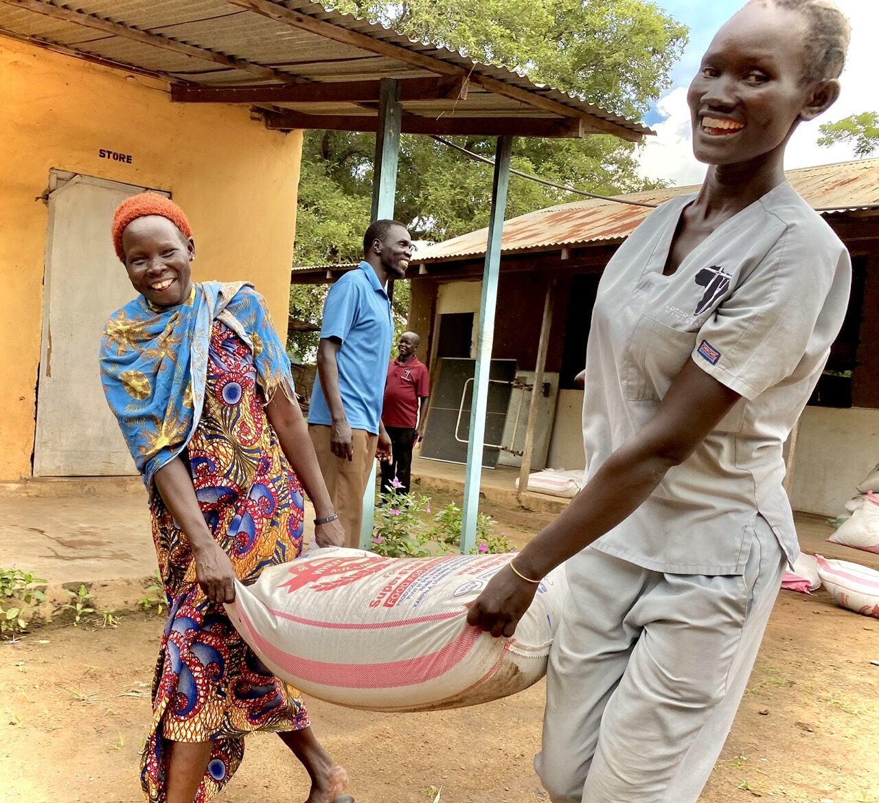 2 ladies carrying away a food bag.