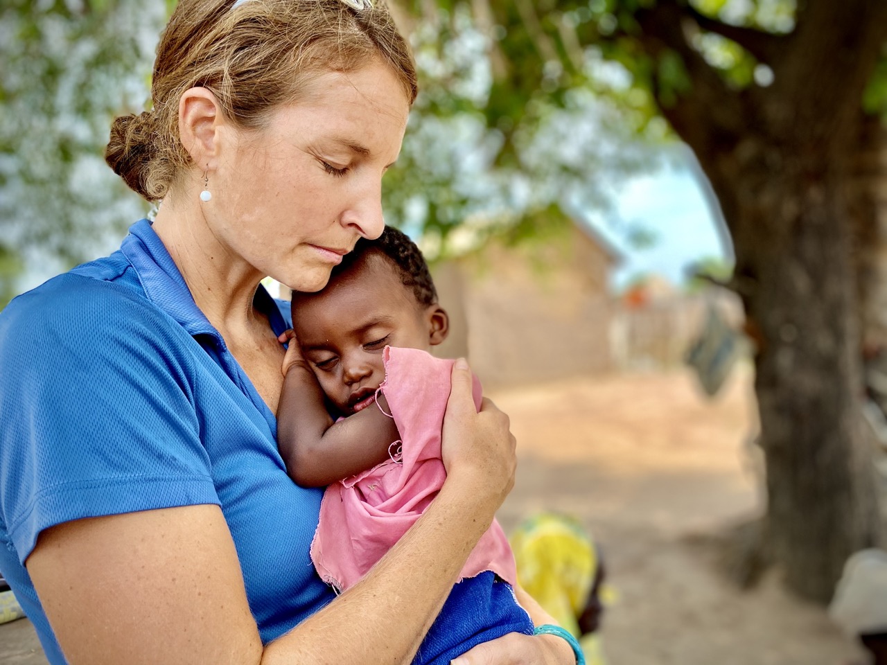 A lady volunteer hugging a child