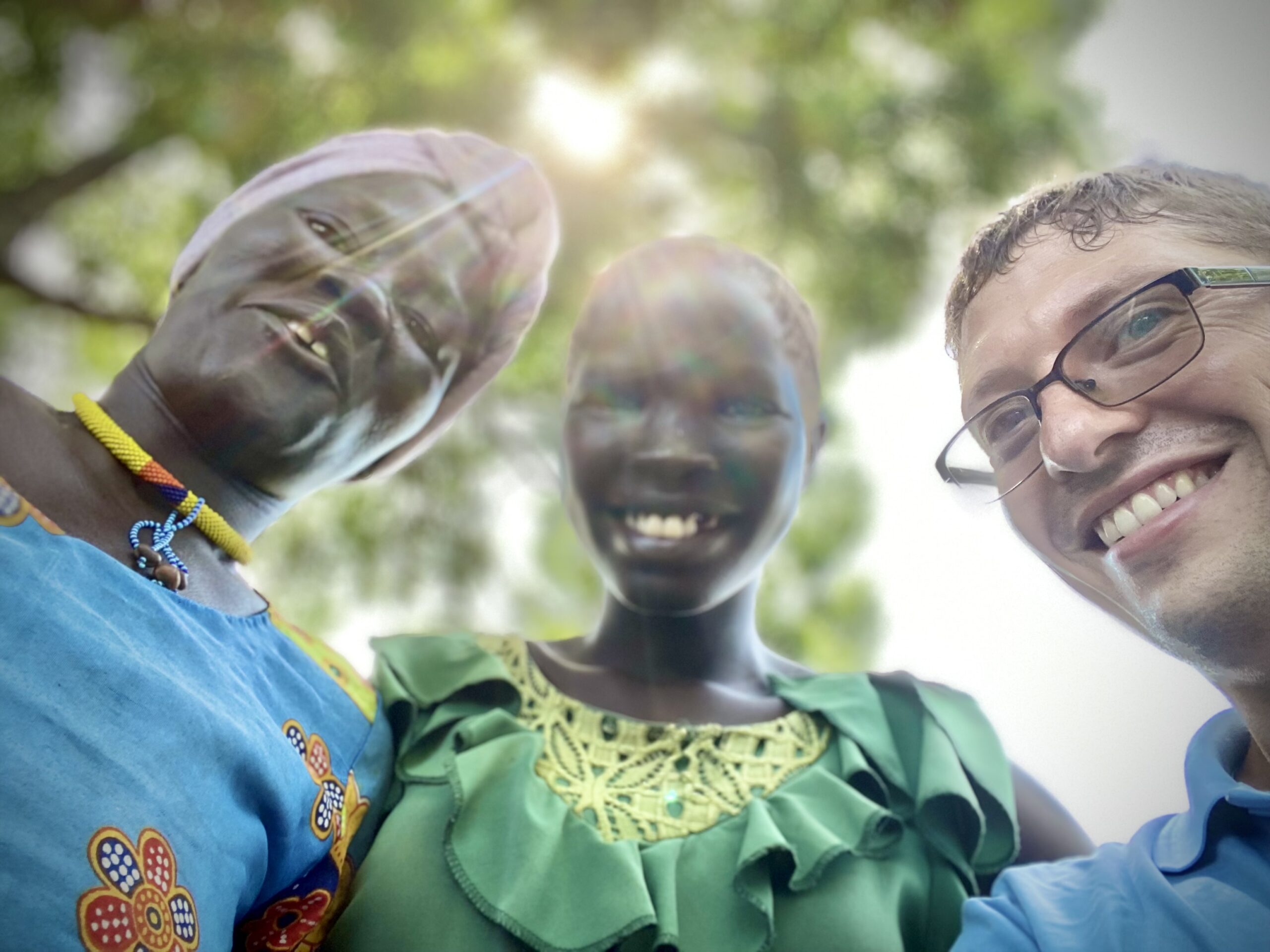 A volunteer and two ladies smile