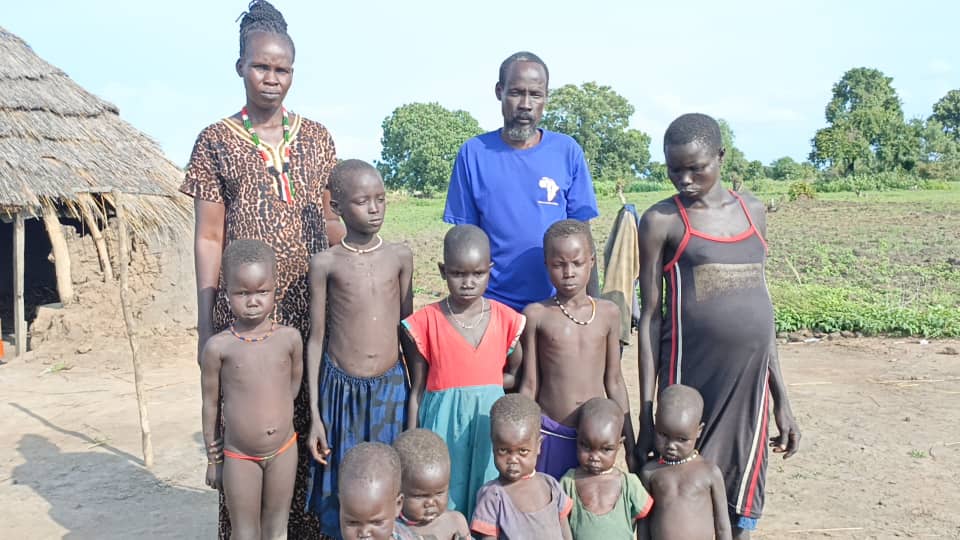 An African family posing in front of their house.