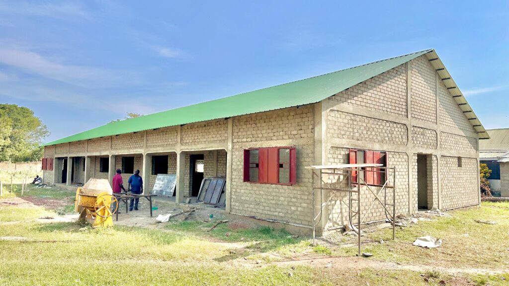 A brick building with green roof under construction